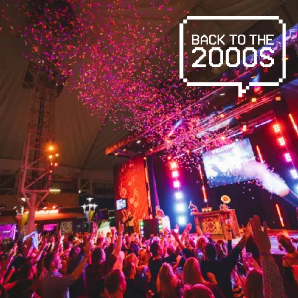 Large party on a butlins adult weekender in the big top with text showing "back to the 2000s"