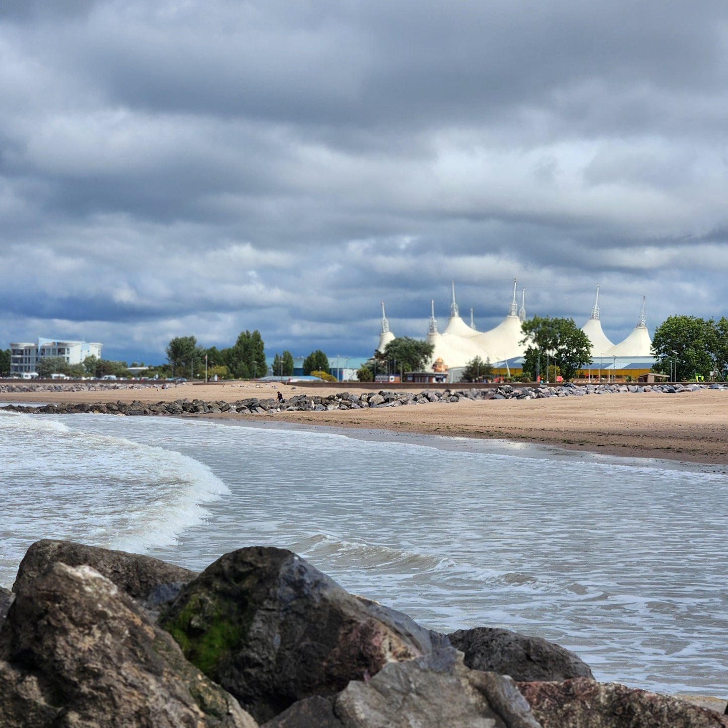 Beach scene with rocks in the foreground and a cloudy sky at Butlin's Minehead.