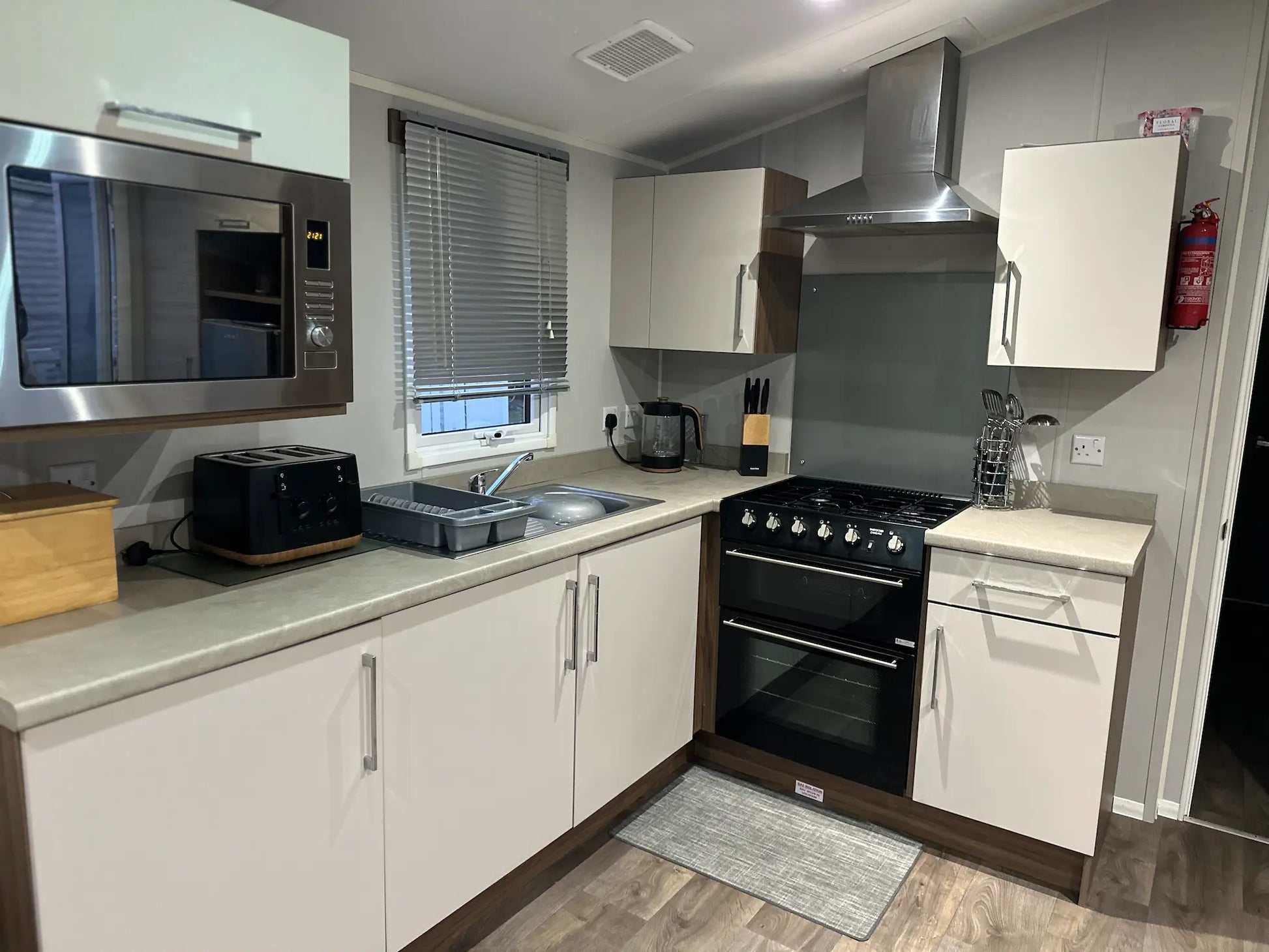 Spacious fully equipped kitchen with a gas cooker, integrated microwave and all utensils in a Butlins Caravan