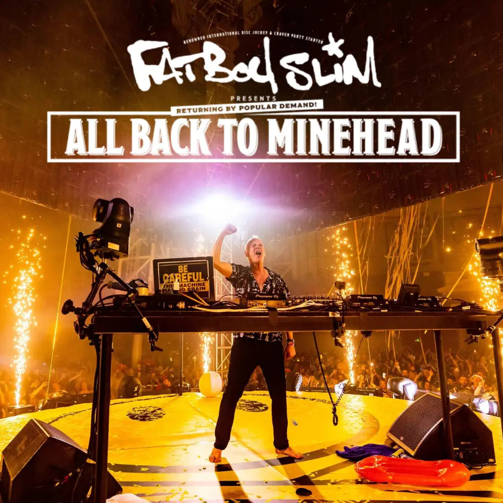Fatboy slim performing onstage during a butlins adult weekender arena break, with "fatboy slim all back to minehead" displayed in text