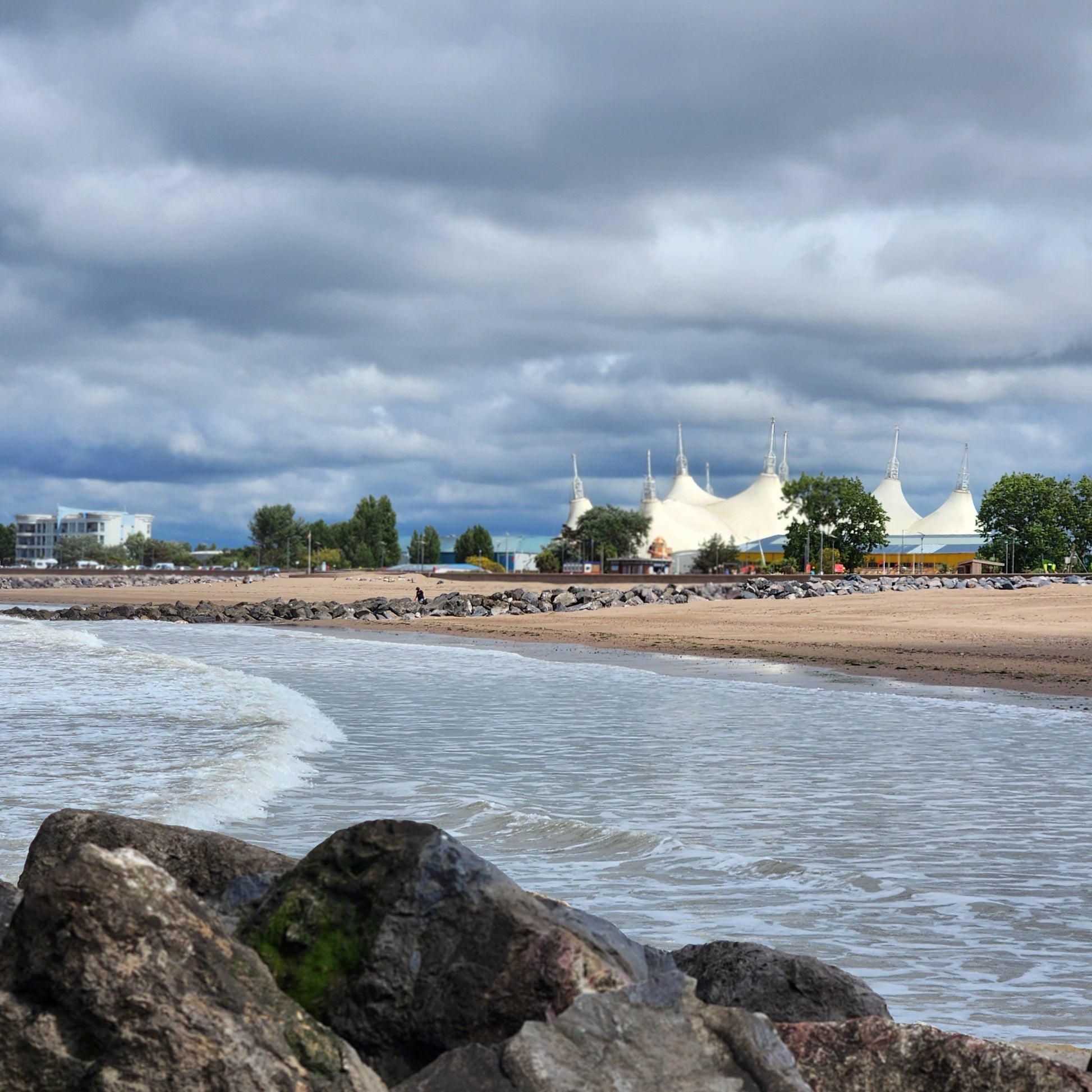 Beach scene with rocks in the foreground and a cloudy sky at Butlin's Minehead.