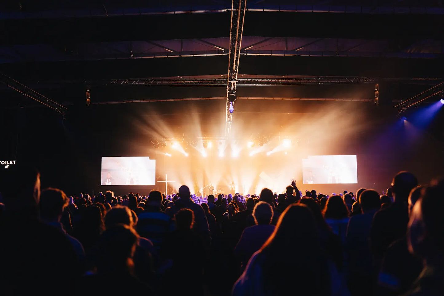 People at Spring Harvest at Butlins Minehead with stage lights and screens