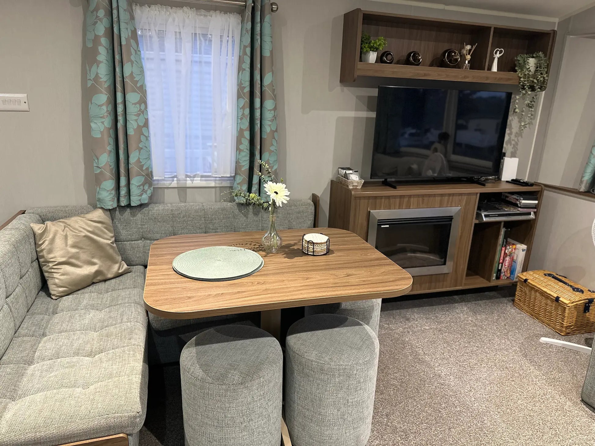 Butlins Caravan Living room with grey sofa, wooden coffee table, and TV stand.